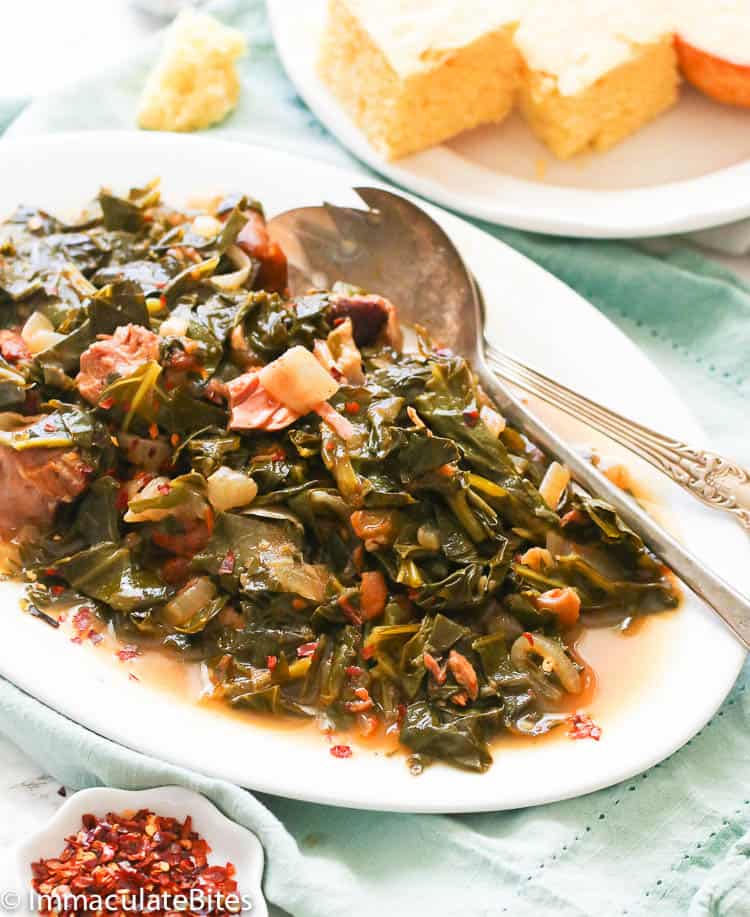 a platter of collard greens recipe with cornbread in the background