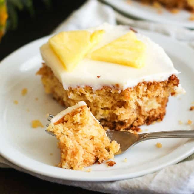 Forking into a piece of cake loaded with pineapple.