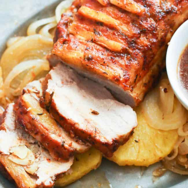 Slow Cooker Pork Loin sliced on a wooden cutting board