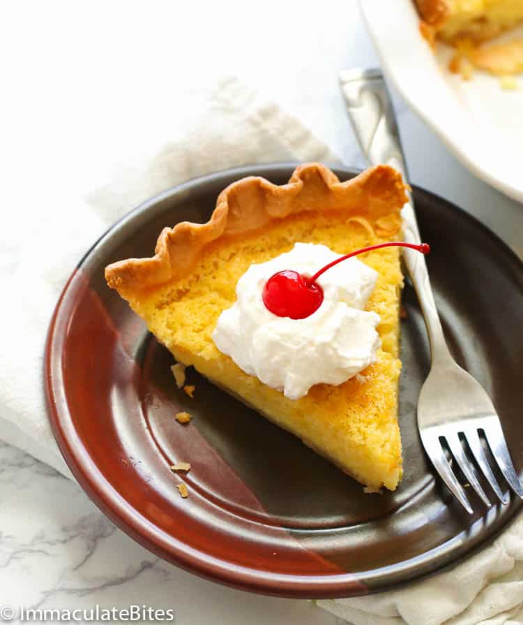 Ready to dive into a slice of decadent Buttermilk Pie topped with whipped cream and a cherry