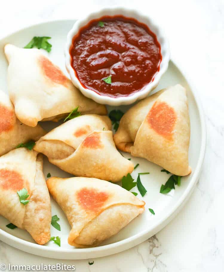 Appetizing samosas with  spicy hot sauce