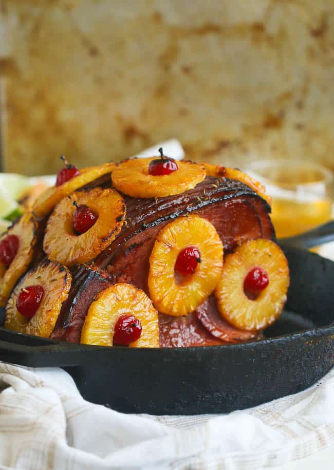 Pineapple Honey Glazed Ham on a Cast-iron and Adorned with Pineapple Rings and Cherries