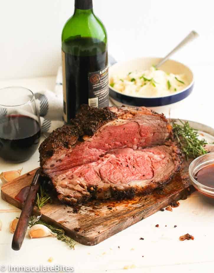prime rib roast on a chopping board served with wine