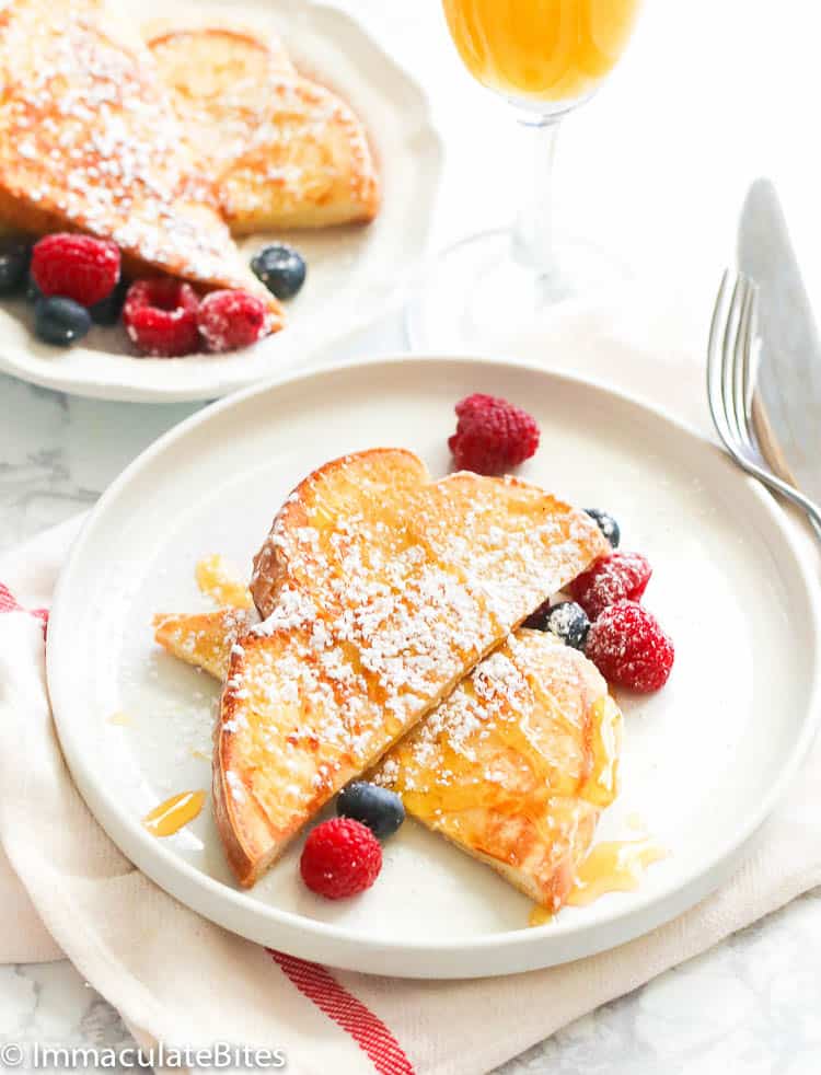 French toast with raspberries on a white plate