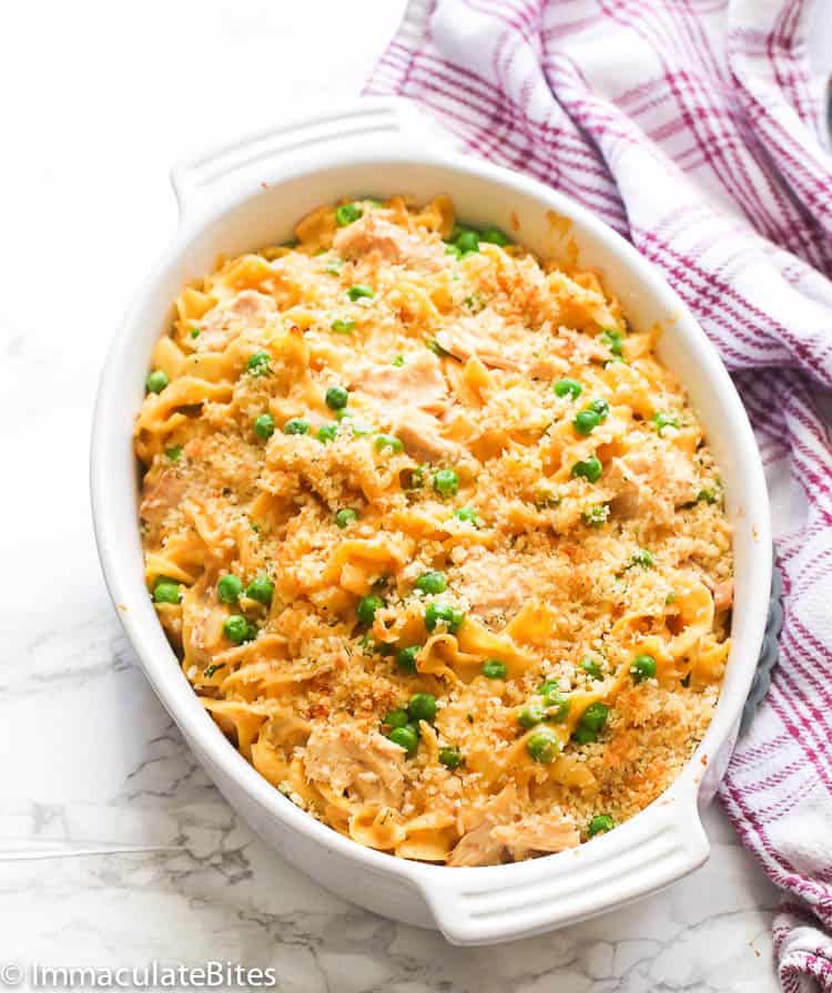 Tuna Noodle Casserole baked on a white baking dish with green peas.