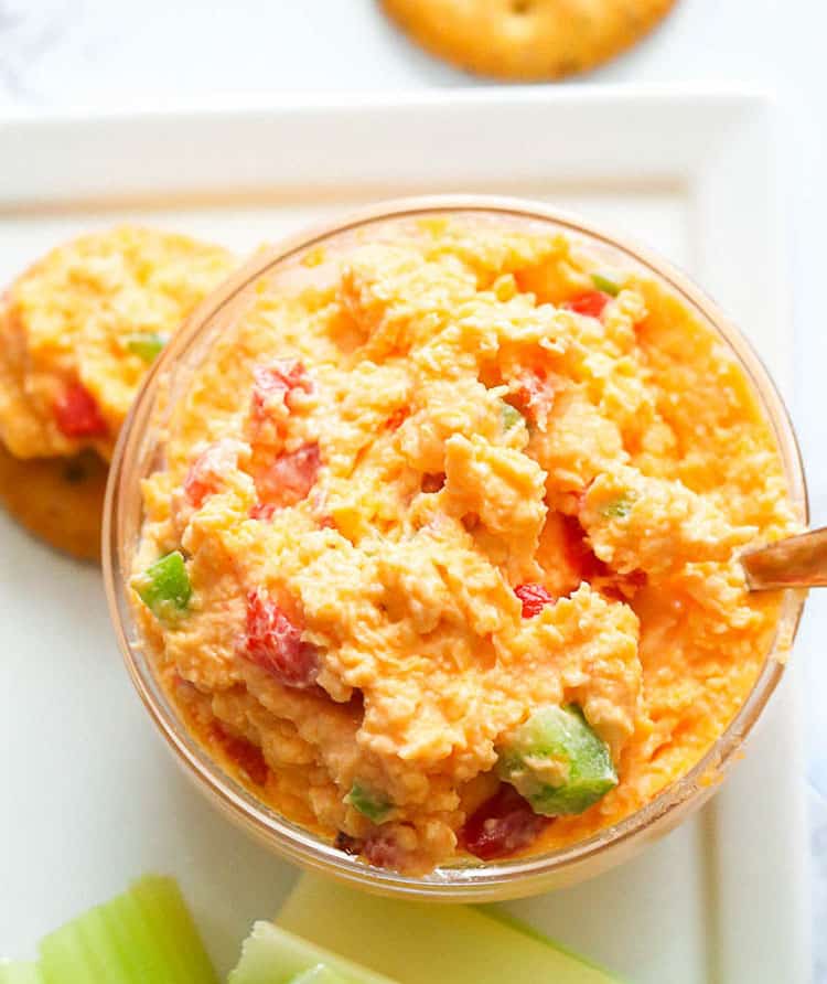 Pimento Cheese in a Small Clear Bowl Served with Celery Sticks and Crackers