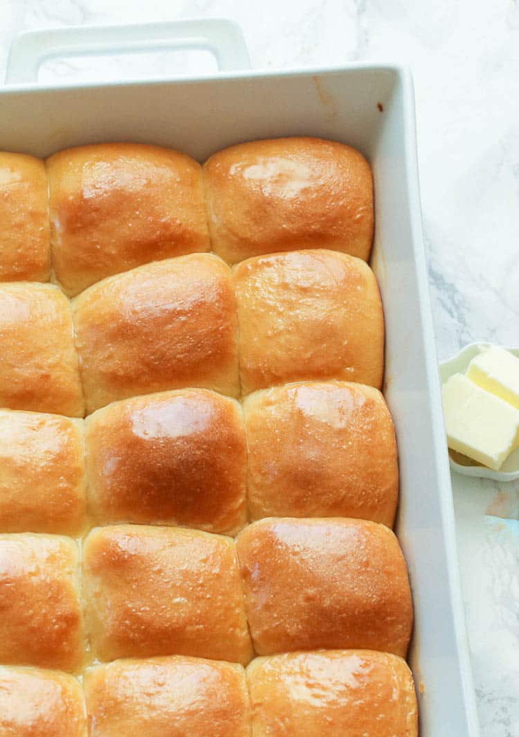 Easy Dinner Rolls with Slices of Butter in the Backrgound