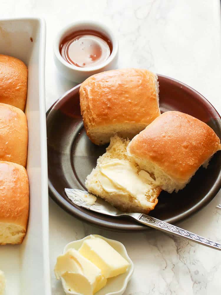 Two Easy Dinner Rolls Served  in a Plate and Smothered with Butter