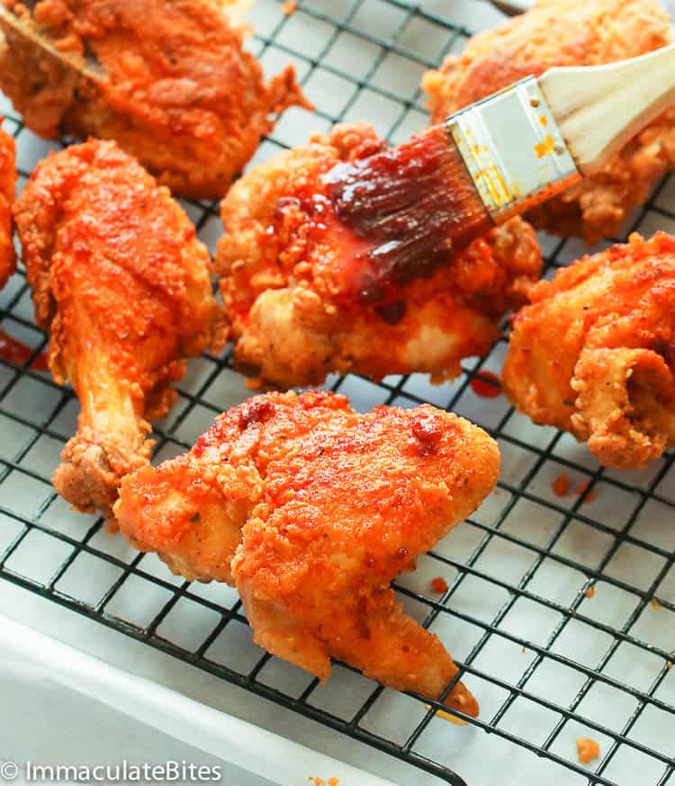 Brushing Nashville hot sauce on freshly fried chicken