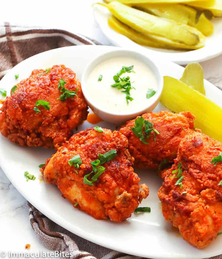 Nashville Hot Chicken on a platter with pickles and remoulade