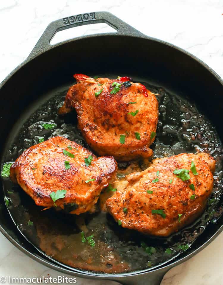 Stuffed Pork Chops hot from the oven in a cast iron skillet ready to enjoy