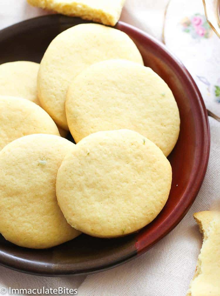 Six tea cakes on a brown plate.