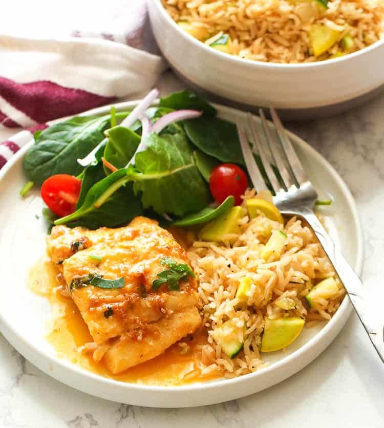 Soul-satisfying rice pilaf with oven-baked cod and a salad, perfect for Fish Friday