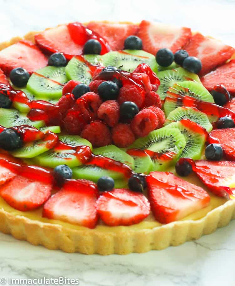 A whole fruit tart with berries and kiwi
