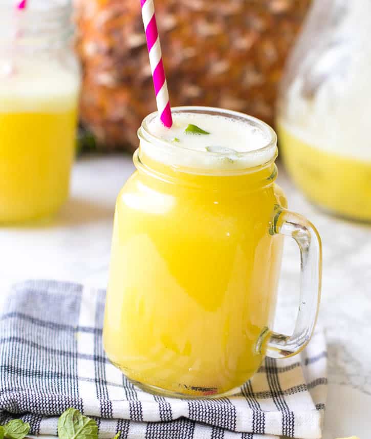 Homemade Pineapple Juice in a pint jar with a straw