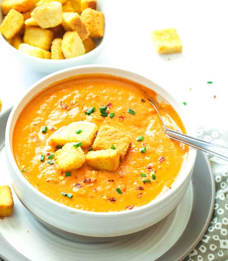 A bowl of tomato bisque topped with croutons