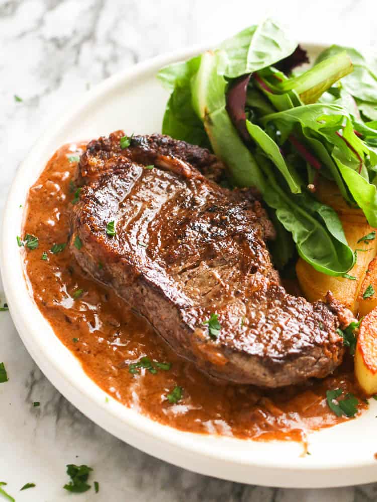 Enjoying an elegant steak Diane with fresh greens