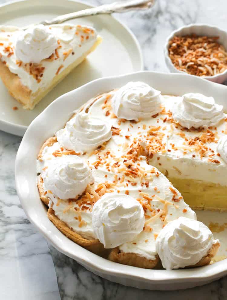 Coconut Cream Pie with a slice on a white plate.