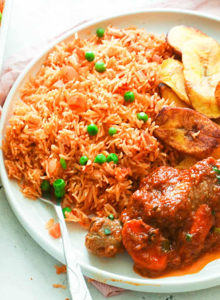 A Plateful of Baked Jollof Rice Served with a Stew and Fried Plantains