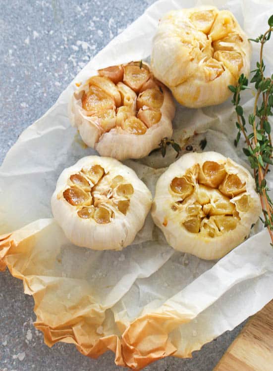 Four Whole Roasted Garlic with a Sprig of Thyme