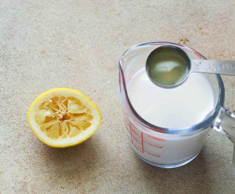 Milk Being Poured with a Tablespoon of Lemon Juice