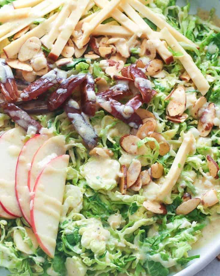 Shaved Brussel Sprouts Salad with dressing and sliced almonds