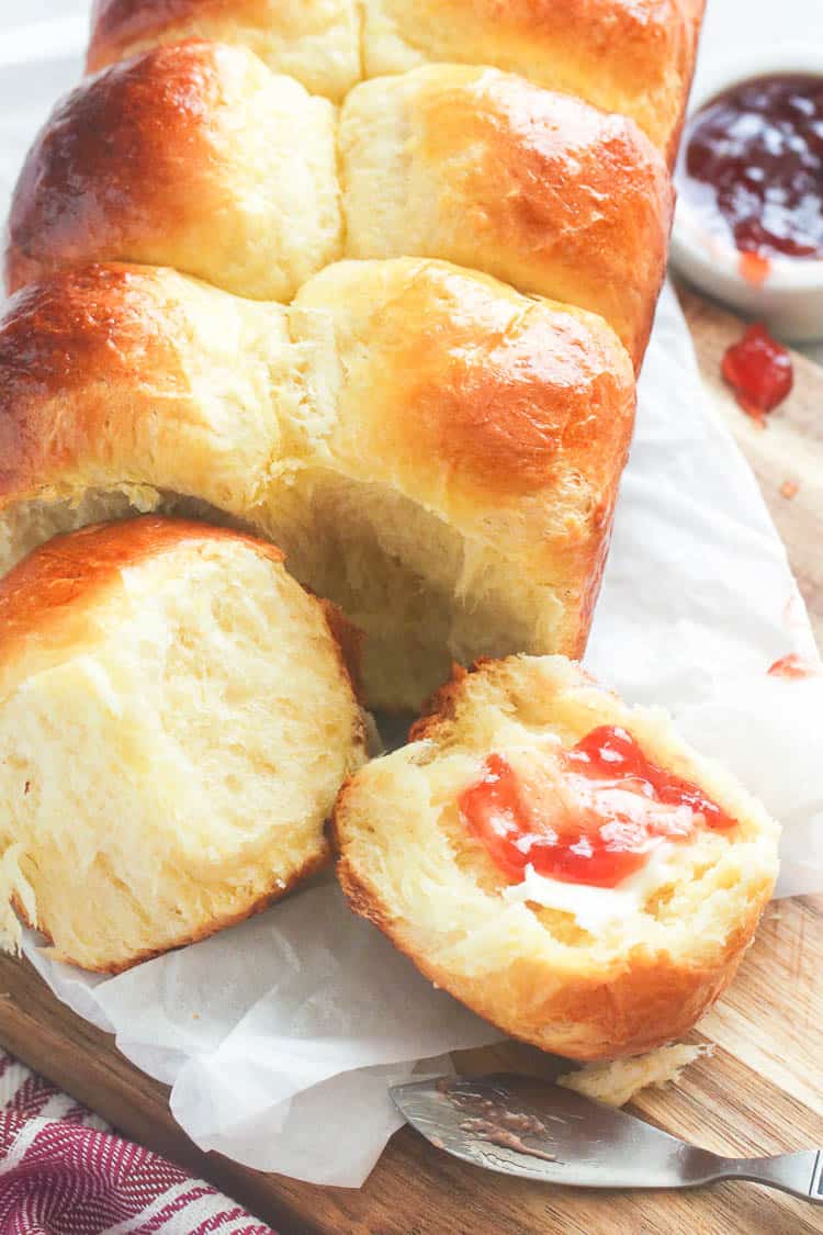 Slathering freshly bake brioche buns with fruit jam