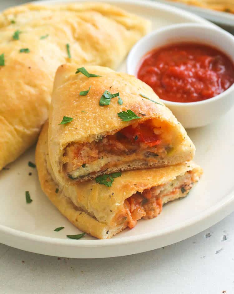 Half-opened Homemade Calzone served on a white dish for fall snacks