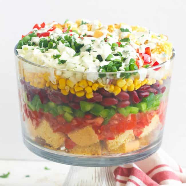Layers of bread and fresh produce in ranch dressing