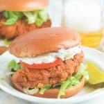 Insanely delicious chicken sandwich with tartar sauce on a white plate