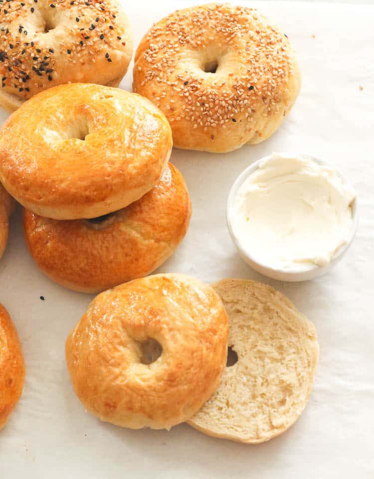 Bagels and cream cheese resting on baking paper.