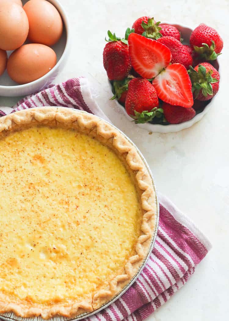 Gorgeous Egg Custard Pie with eggs and berries in the background