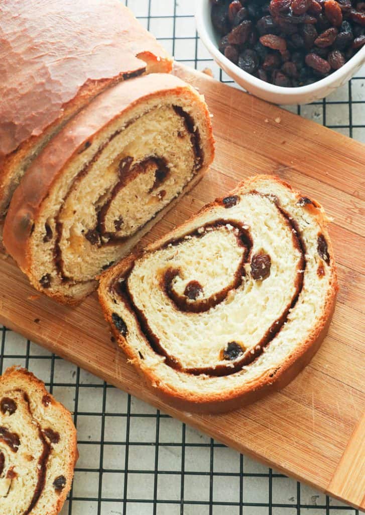 Sliced Cinnamon Raisin Bread on a Chopping Bread with Raisins in the Background