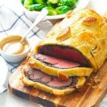 Slicing into Beef Wellington with wine sauce on the side