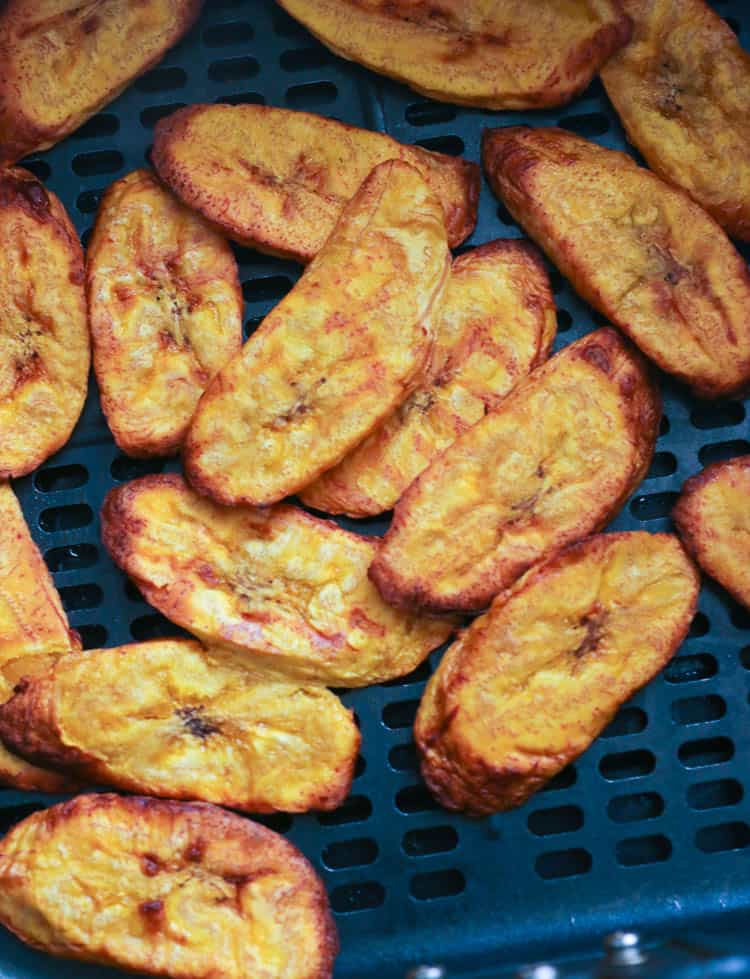 Sliced plantains in an air fryer basket