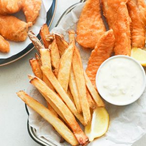 Fish and chips with tartar sauce on a small platter