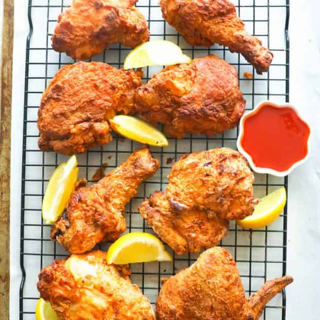 Air Fryer Southern Fried Chicken in a cooling rack with lemon wedges