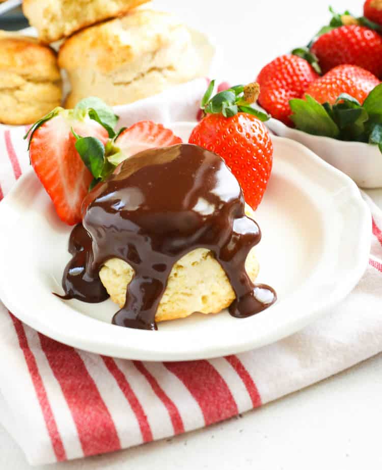 Southern biscuits topped with chocolate gravy and strawberries on the side