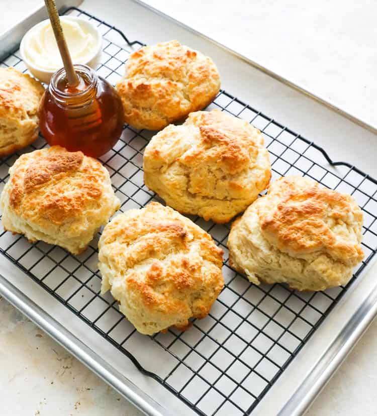 Cathead Biscuits on a cooling rack with honey and butter