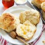 Biscuits with honey dipper on a white plate