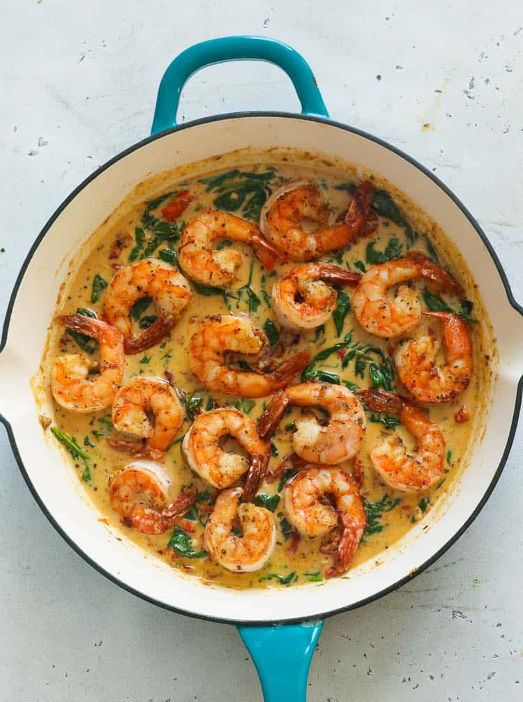 shrimps on pasta with a silver fork on a white plate