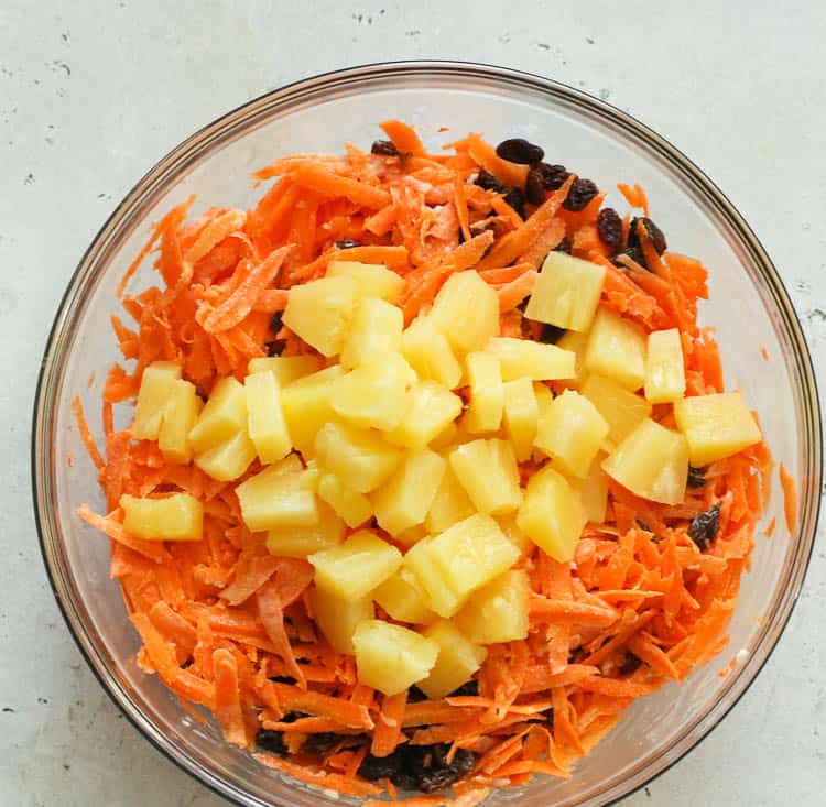 carrots, pineapple chunks, raisins in a bowl ready for mixing