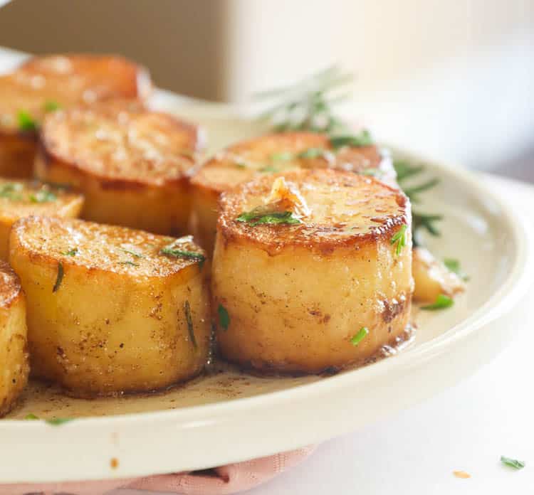 Close-up Side Shot of Fondant Potatoes in a White Plate