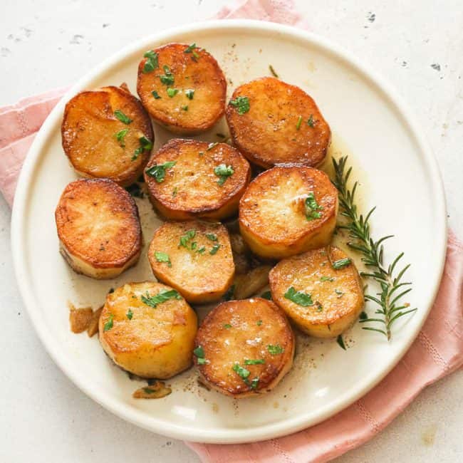 fondant potatoes on a white plate ready to accompany your steak dinner