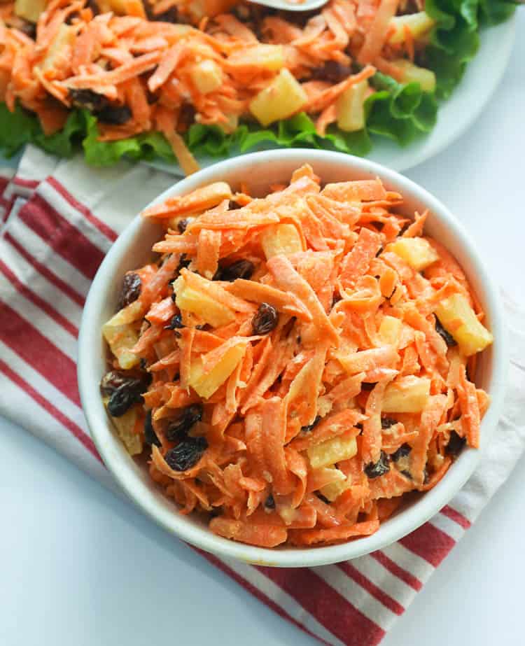 carrot raisin salad in a white bowl