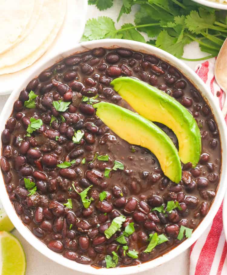 cooked black beans with slices of avocado