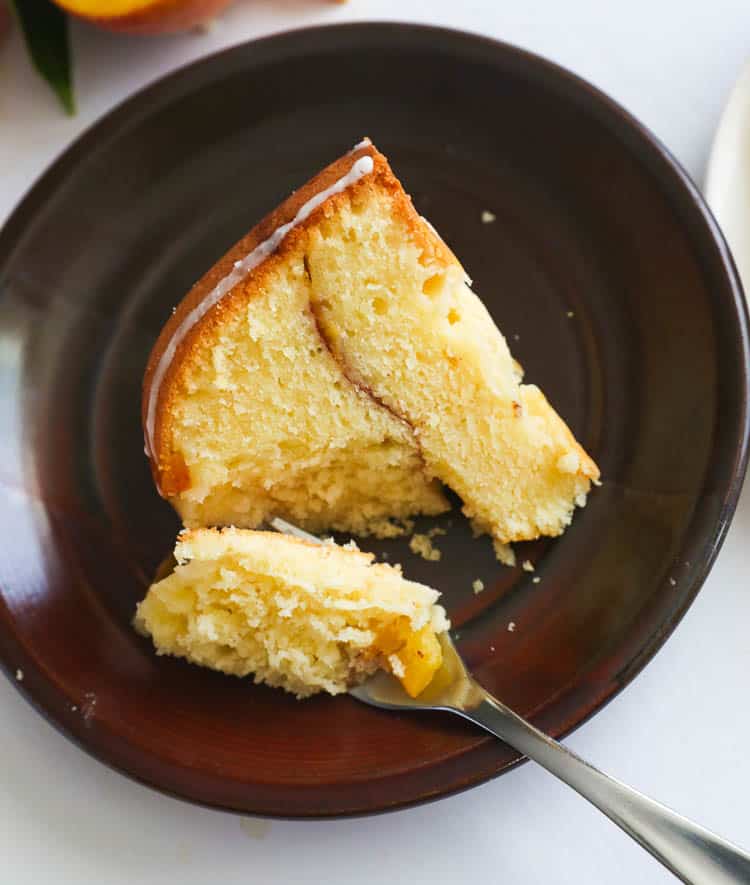 A slice of peach cobbler pound cake on a black cake