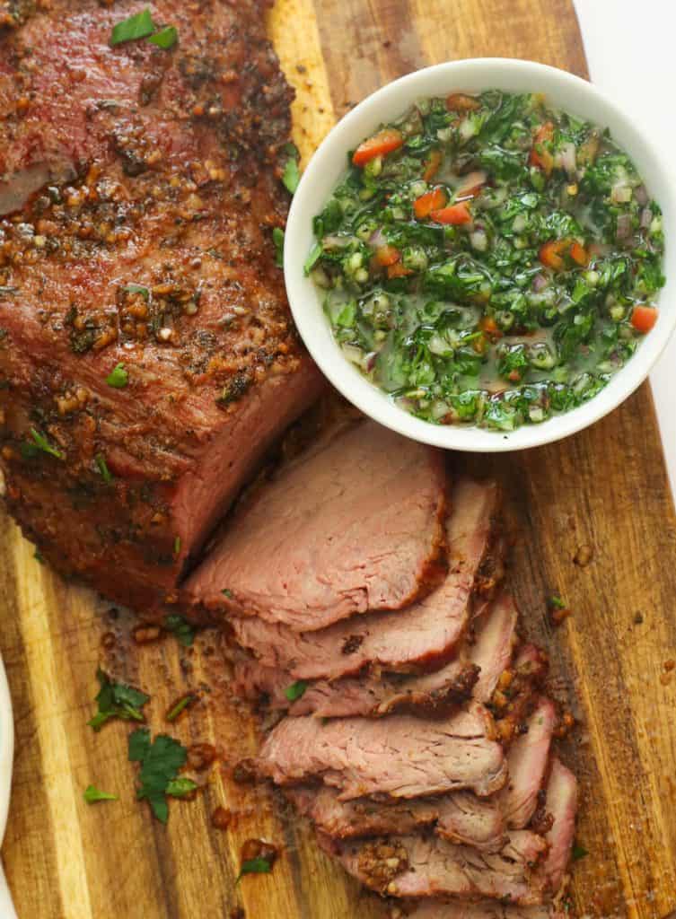smoked beef on a chop board with marinade ingredients