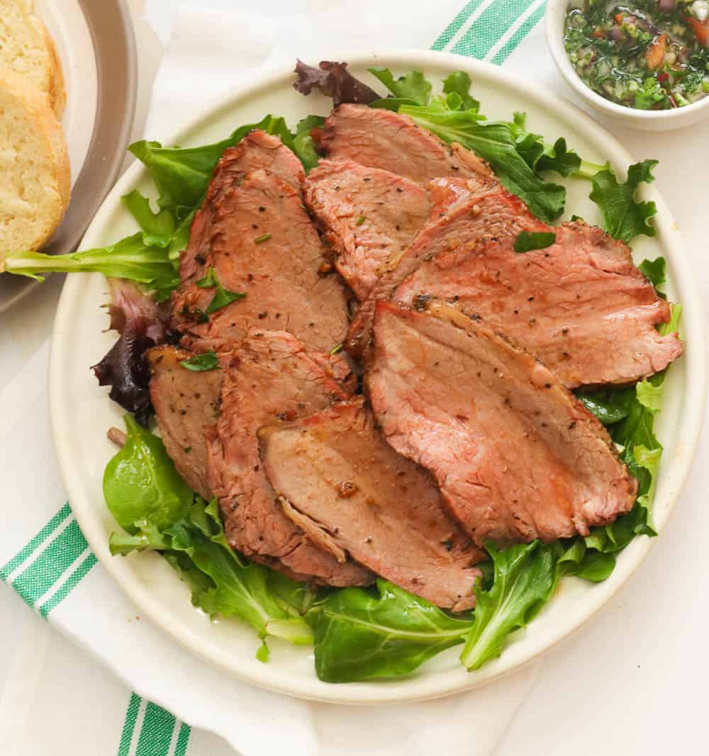 sliced beef on a bed of greens