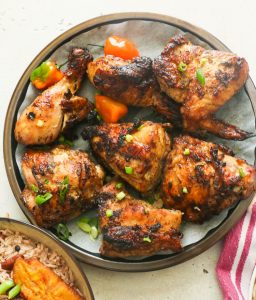 6 pieces of insanely delicious jerk chicken on a plate